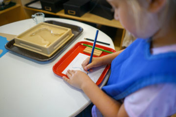 kid learning to fill color in our draw class of montessori school