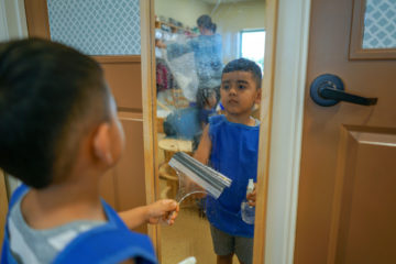 kid cleaning mirror while learning
